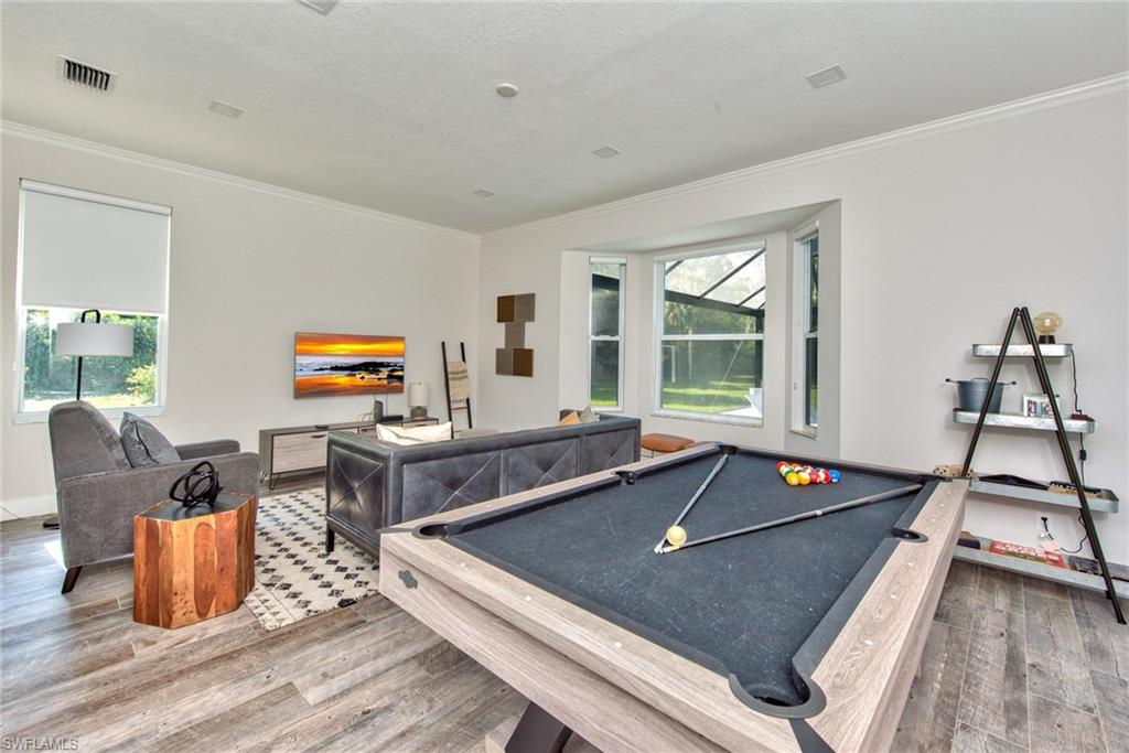 6106 Copper Leaf Lane Naples, FL 34116 - Photo 8 of 35 a living room with furniture flat screen tv and a large window