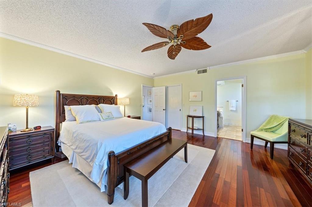 760 Willowbrook Drive, Unit 1204 Naples, FL 34108 - Photo 13 of 25 a bedroom with a bed and wooden floor