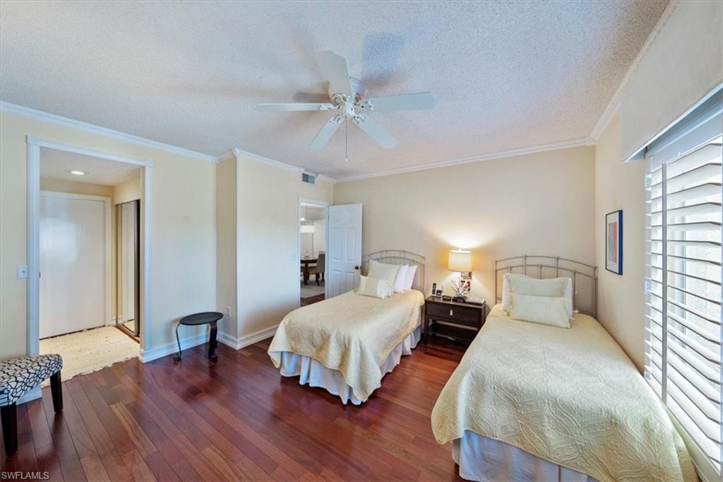 760 Willowbrook Drive, Unit 1204 Naples, FL 34108 - Photo 17 of 25 a bedroom with a bed and a chandelier