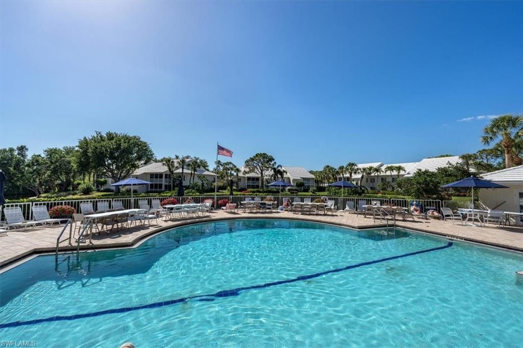 760 Willowbrook Drive, Unit 1204 Naples, FL 34108 - Photo 23 of 25 a view of a swimming pool with outdoor seating and a garden