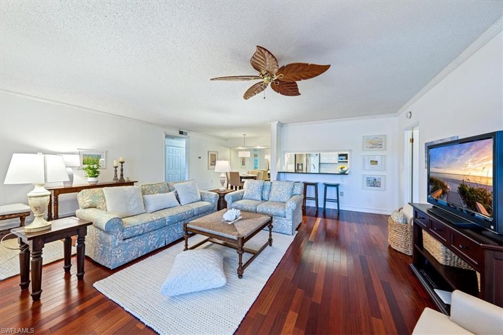 760 Willowbrook Drive, Unit 1204 Naples, FL 34108 - Photo 3 of 25 a living room with furniture and a flat screen tv