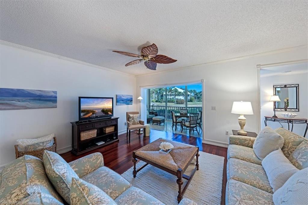 760 Willowbrook Drive, Unit 1204 Naples, FL 34108 - Photo 4 of 25 a living room with furniture a ceiling fan and a flat screen tv