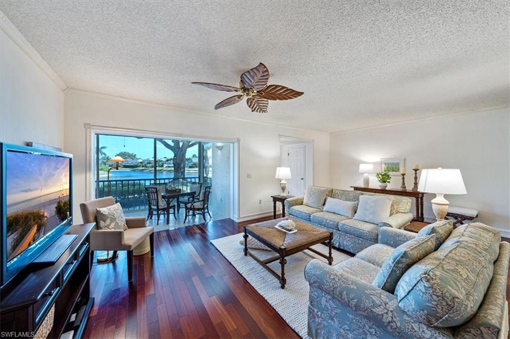 760 Willowbrook Drive, Unit 1204 Naples, FL 34108 - Photo 5 of 25 a living room with furniture a flat screen tv and a large window