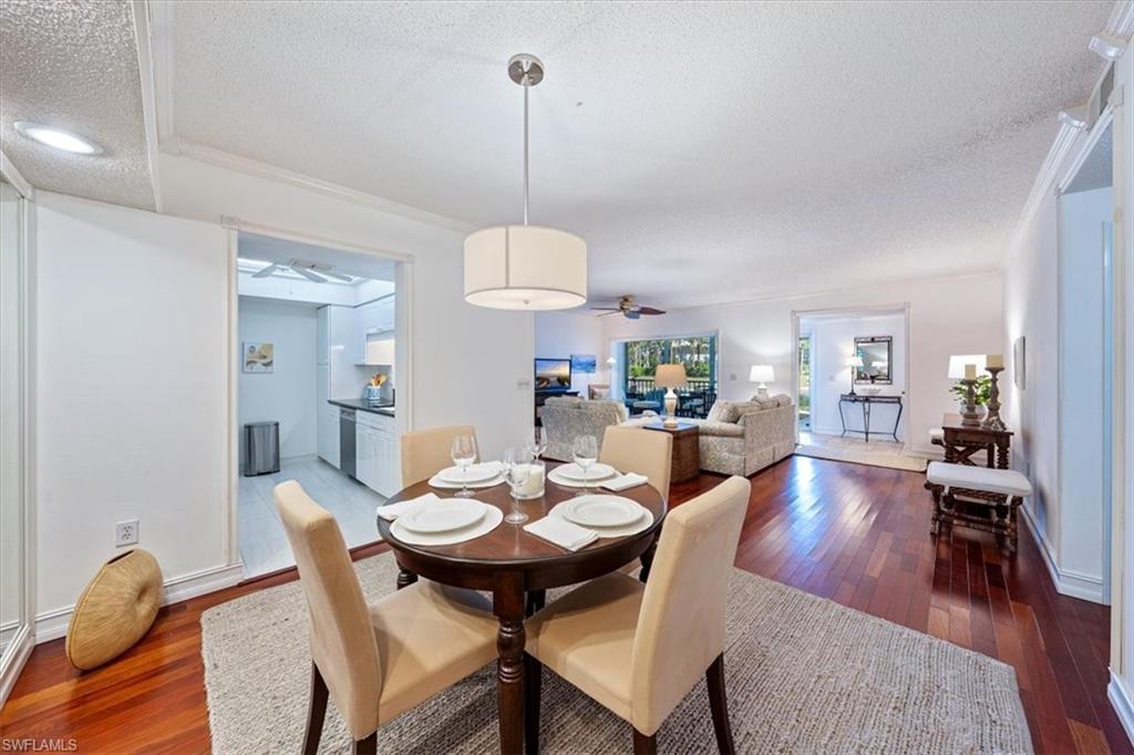 760 Willowbrook Drive, Unit 1204 Naples, FL 34108 - Photo 8 of 25 a view of a dining room and livingroom furniture wooden floor a rug and a chandelier