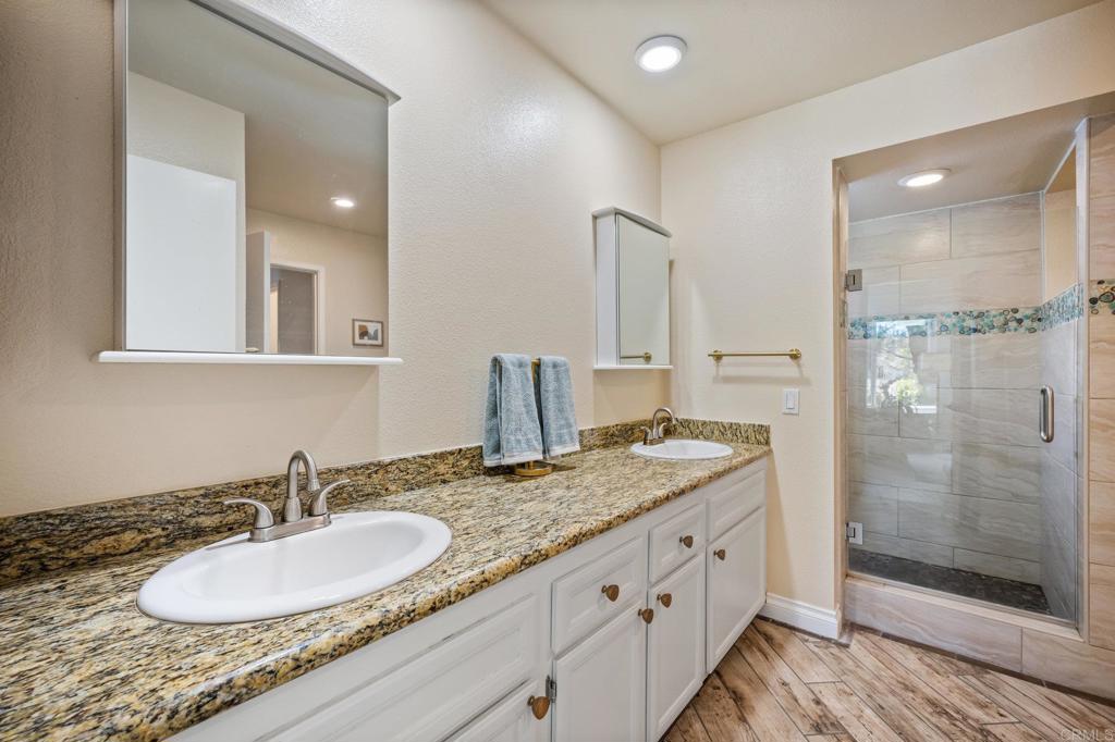 1935 Sunset Drive, Unit 96 Escondido, CA 92025 - Photo 11 of 24 a bathroom with a granite countertop double vanity sink and a mirror