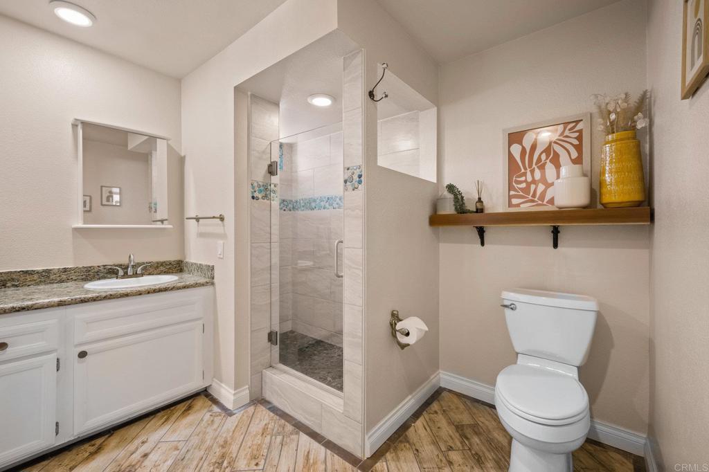 1935 Sunset Drive, Unit 96 Escondido, CA 92025 - Photo 12 of 24 a bathroom with a granite countertop toilet sink and mirror