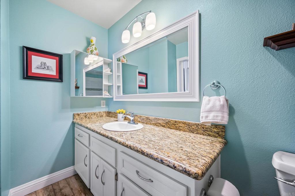 1935 Sunset Drive, Unit 96 Escondido, CA 92025 - Photo 18 of 24 a bathroom with a granite countertop sink and a mirror