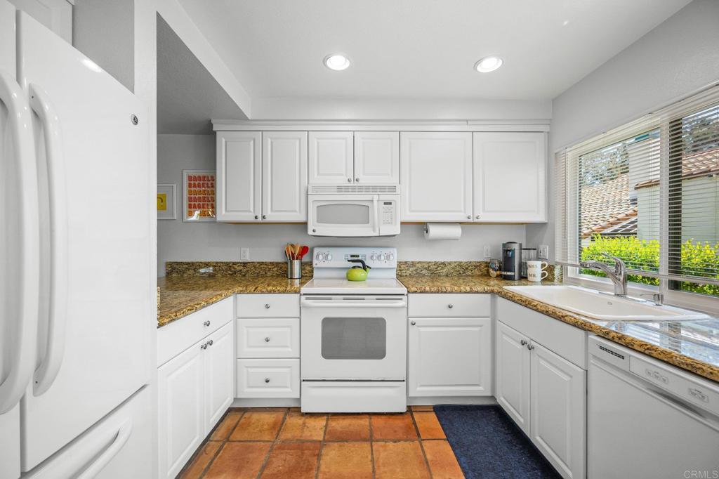1935 Sunset Drive, Unit 96 Escondido, CA 92025 - Photo 4 of 24 a kitchen with white cabinets and white appliances