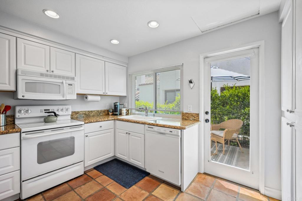 1935 Sunset Drive, Unit 96 Escondido, CA 92025 - Photo 6 of 24 a kitchen with a white stove top oven and white cabinets
