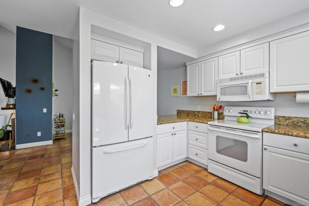 1935 Sunset Drive, Unit 96 Escondido, CA 92025 - Photo 8 of 24 a kitchen with white cabinets and white appliances