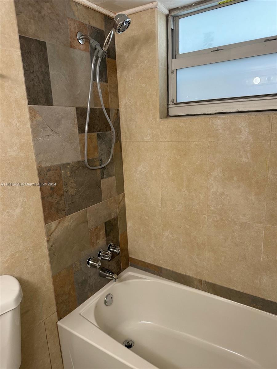 8000 Harding Avenue, Unit 4D Miami Beach, FL 33141 - Photo 7 of 16 a bathroom with a white bath tub and a shower