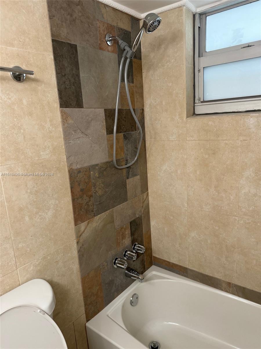 8000 Harding Avenue, Unit 4D Miami Beach, FL 33141 - Photo 8 of 16 a bathroom with a sink a toilet and shower
