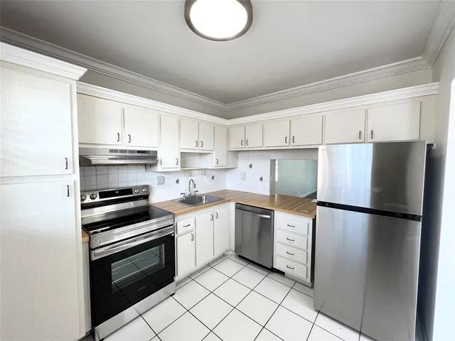 a kitchen with cabinets stainless steel appliances and a window