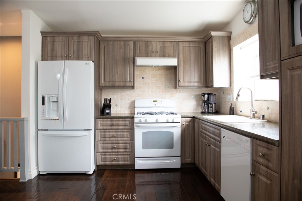 201 21st Place, Unit 2 Manhattan Beach, CA 90266 - Photo 5 of 25 a kitchen with a refrigerator sink and cabinets