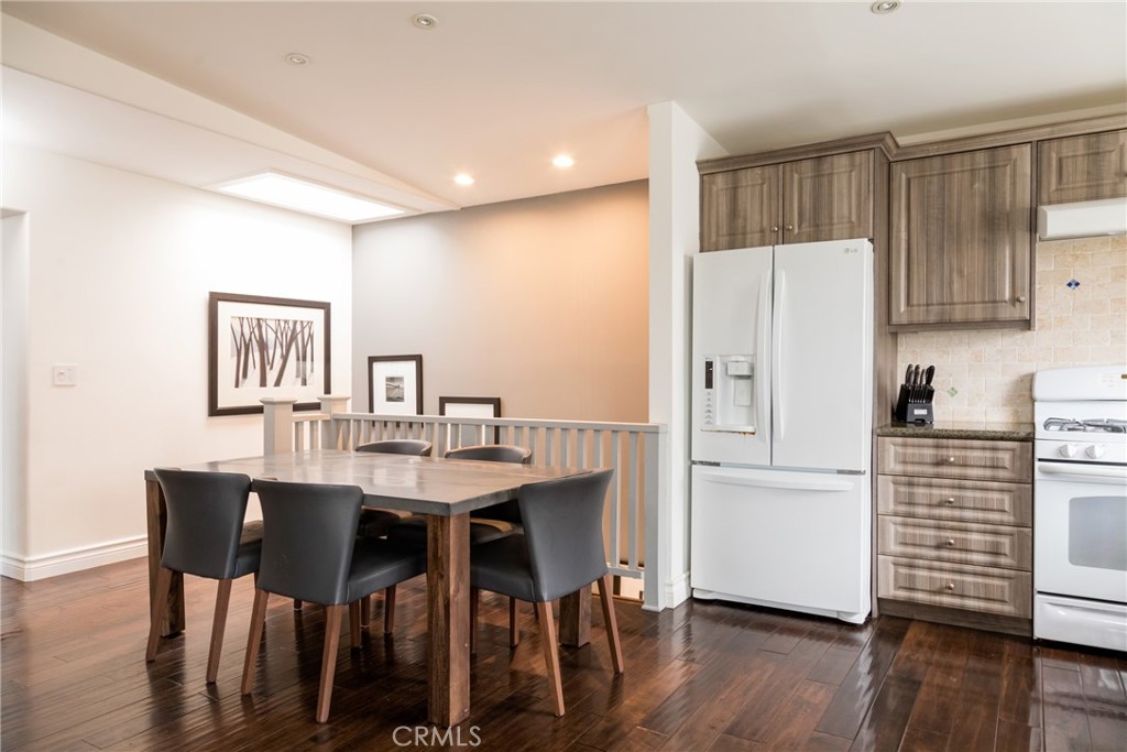 201 21st Place, Unit 2 Manhattan Beach, CA 90266 - Photo 6 of 25 a kitchen with a table chairs refrigerator and cabinets