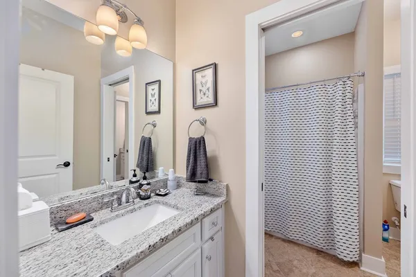 a bathroom with a granite countertop sink and a mirror