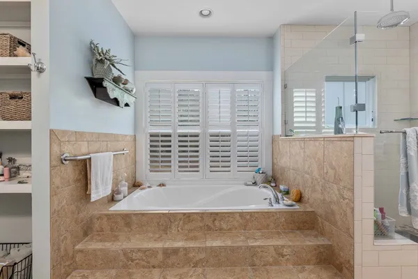 a bathroom with a tub sink and mirror