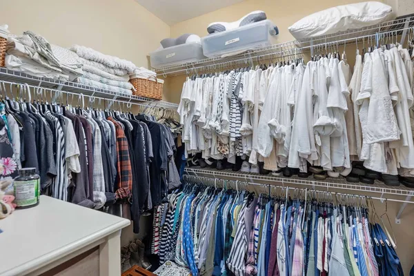 a view of walk in closet with clothes and shoes