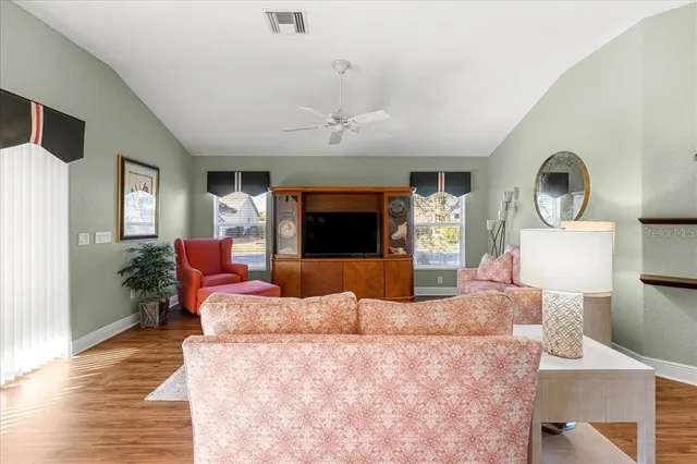 a dining room with furniture a chandelier and wooden floor