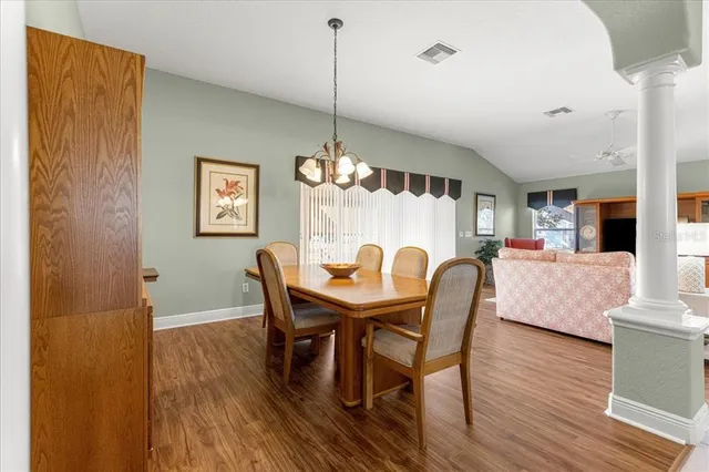 a dining room with furniture a chandelier and wooden floor
