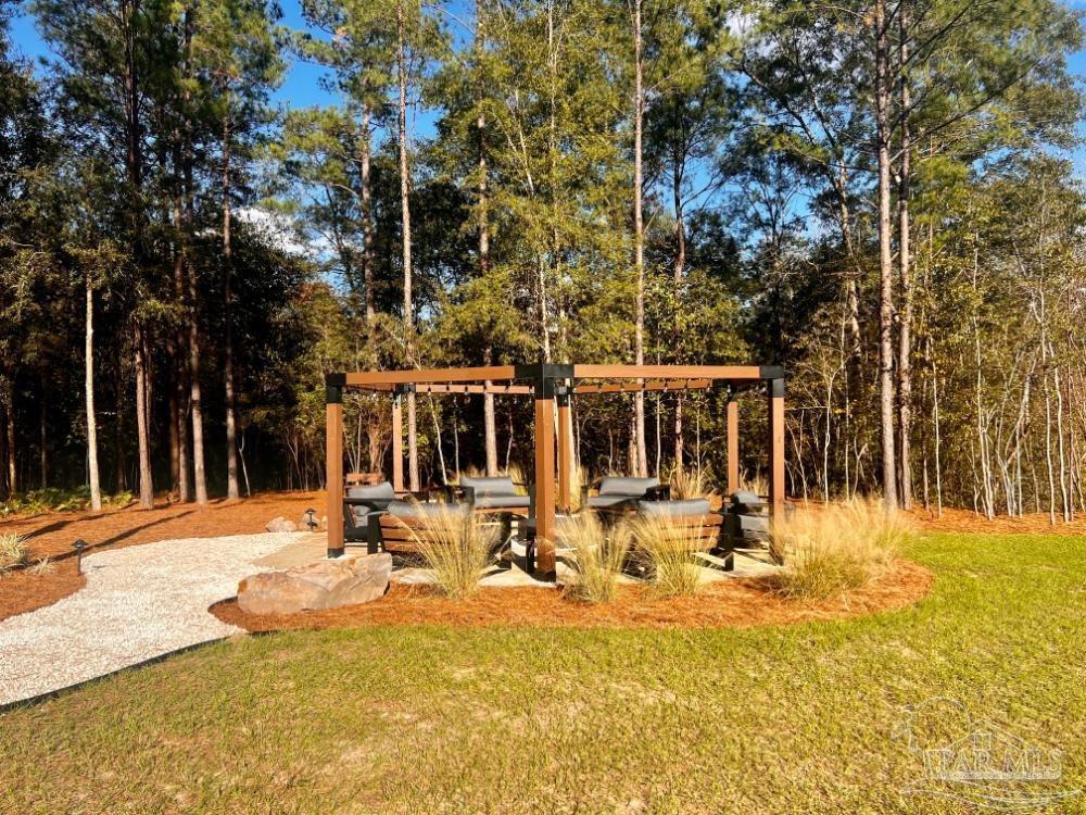 27 Ashbridge Lane Pace, FL 32571 - Photo 22 of 40 a view of a swimming pool with a lawn chairs and plants