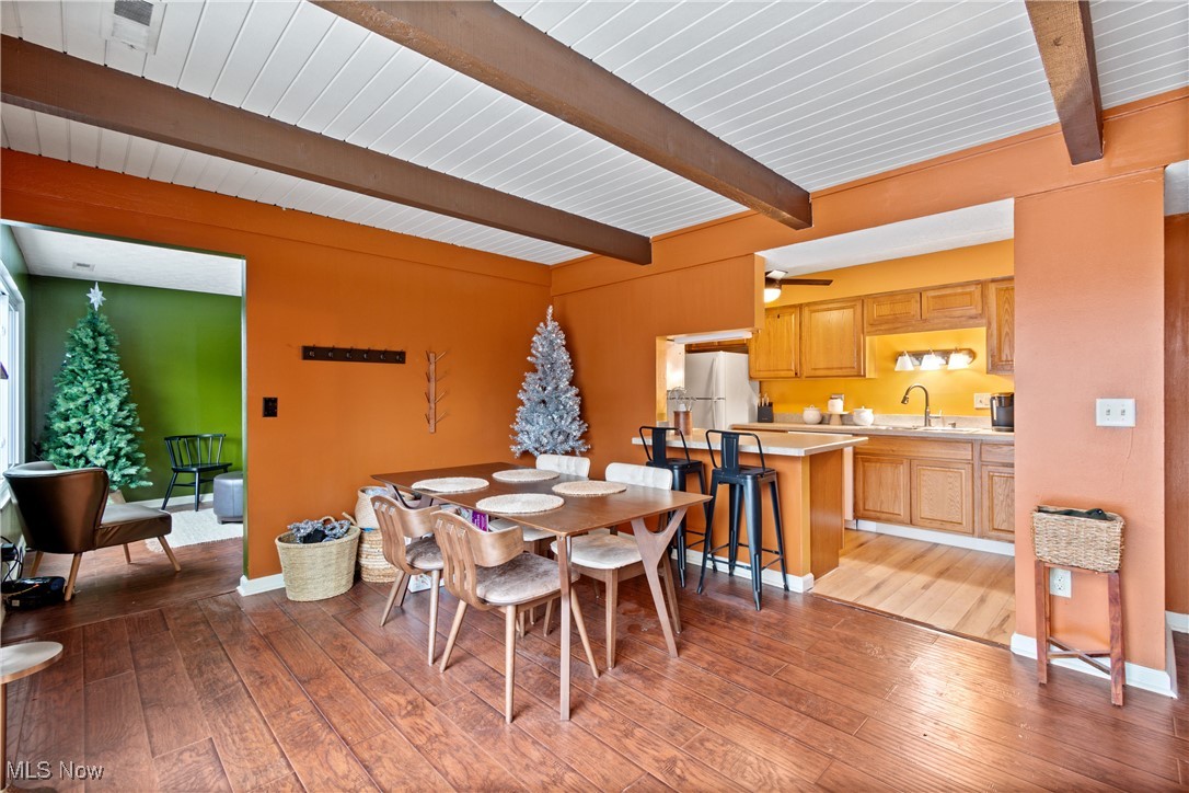 9956 Johnnycake Ridge Road, Unit F4 Painesville, OH 44077 - Photo 7 of 25 Dining room with ceiling fan, beam ceiling, sink, and light hardwood / wood-style flooring