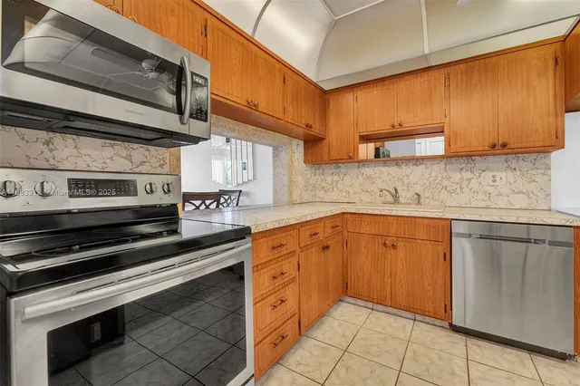 a kitchen with stainless steel appliances granite countertop a sink and cabinets