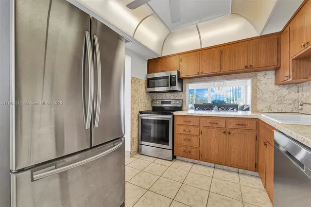 a kitchen with stainless steel appliances a refrigerator sink and microwave