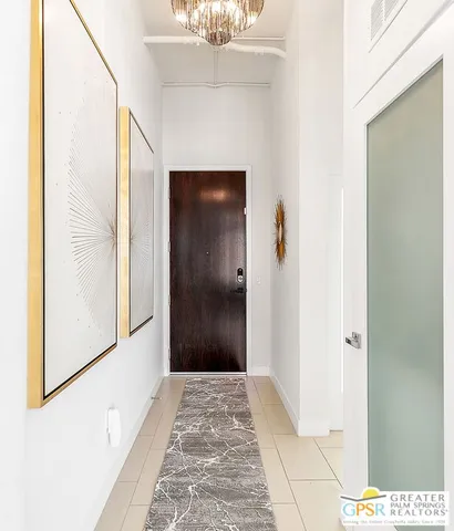 a view of a hallway with wooden floor and a bathroom