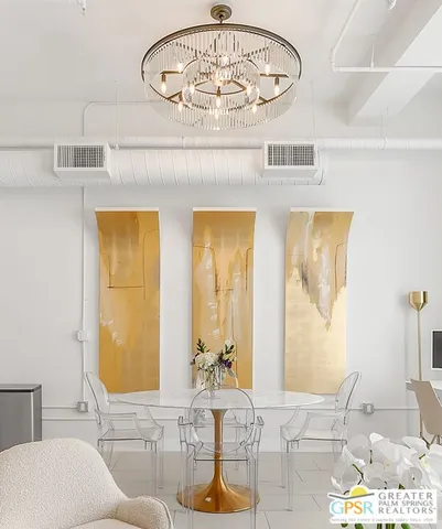 a living room with a table and a chandelier