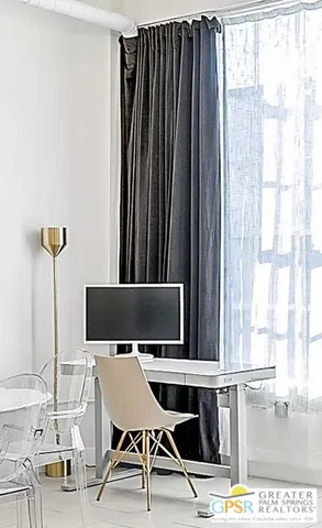 a view of a workspace with furniture and window