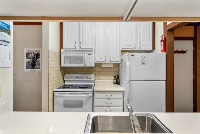 a white refrigerator freezer and a stove sitting inside of a kitchen