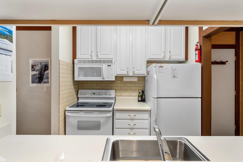440 Shirley Cyn Road, Unit 50 Olympic Valley, CA 96146 - Photo 11 of 28 a white refrigerator freezer and a stove sitting inside of a kitchen