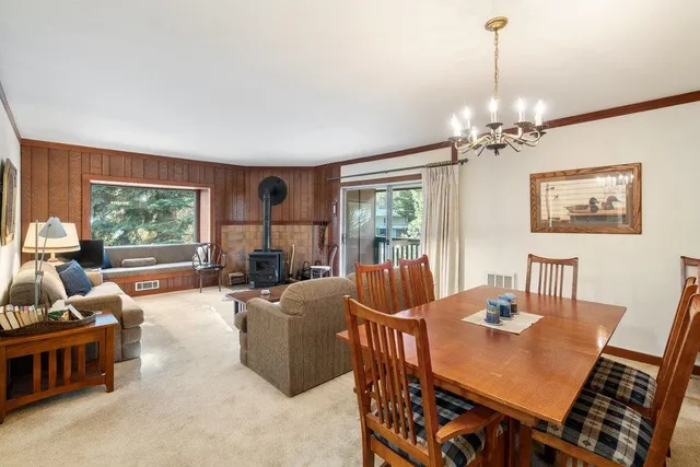 a living room with furniture a chandelier and a dining table