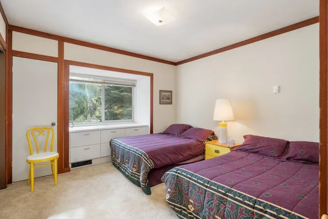 a bedroom with two beds and painting on the wall