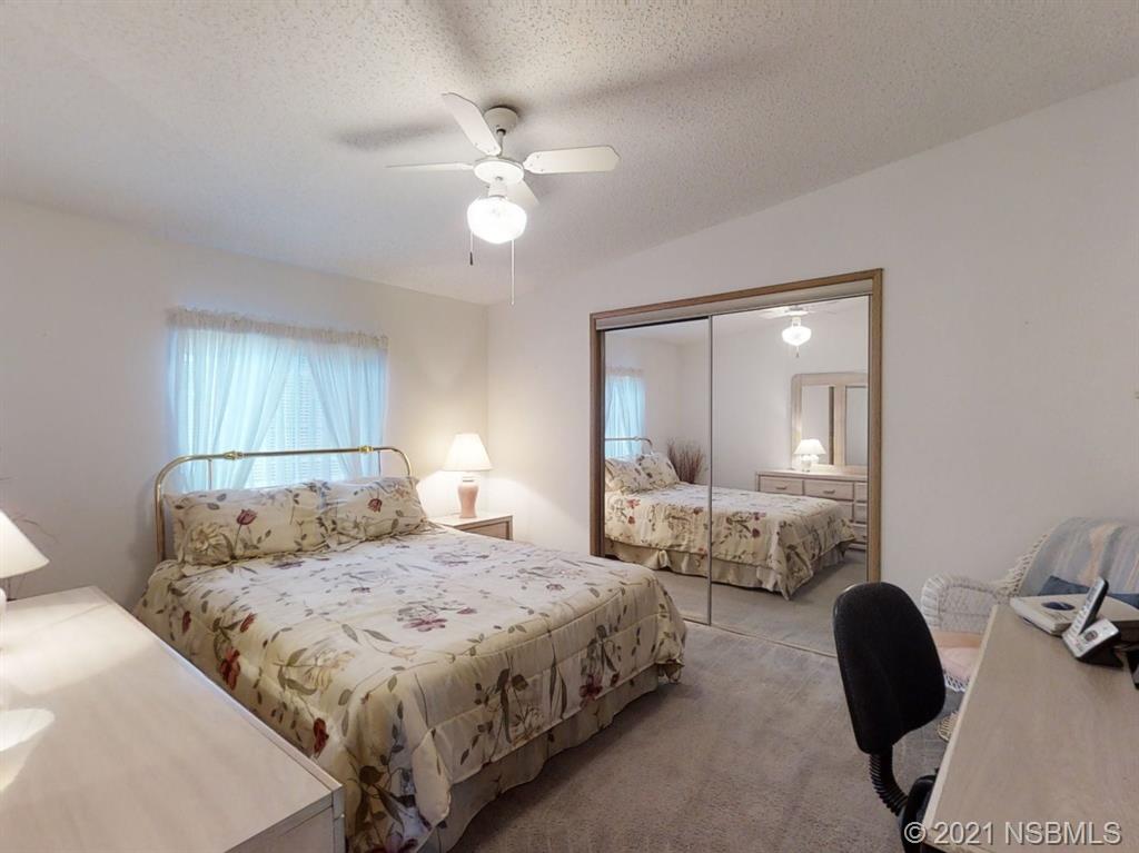 705 Navigators Way Edgewater, FL 32141 - Photo 14 of 33 a bedroom with a large bed and a chandelier