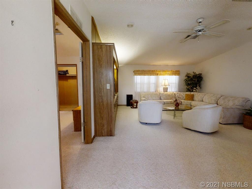 705 Navigators Way Edgewater, FL 32141 - Photo 3 of 33 a living room with furniture and a chandelier