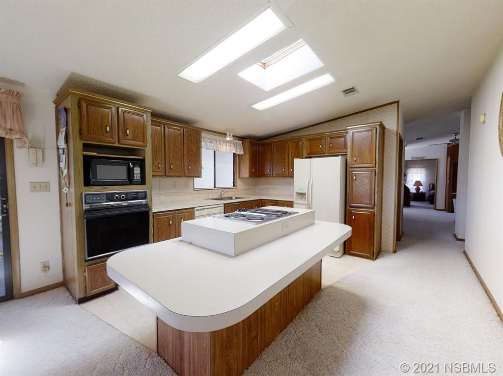 705 Navigators Way Edgewater, FL 32141 - Photo 22 of 33 a kitchen that has a stove and a refrigerator