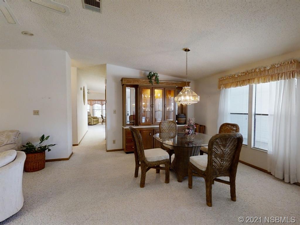 705 Navigators Way Edgewater, FL 32141 - Photo 4 of 33 a dining room with furniture and a chandelier