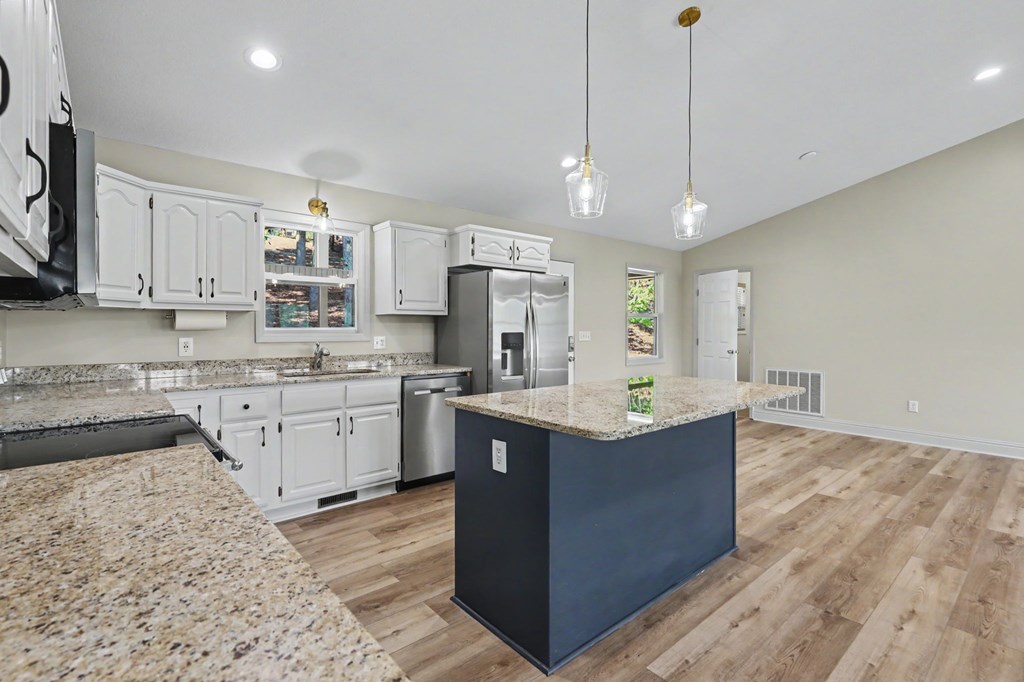 456 Deaver Cove Road Blairsville, GA 30512 - Photo 16 of 83 a kitchen with kitchen island granite countertop a sink cabinets and wooden floor