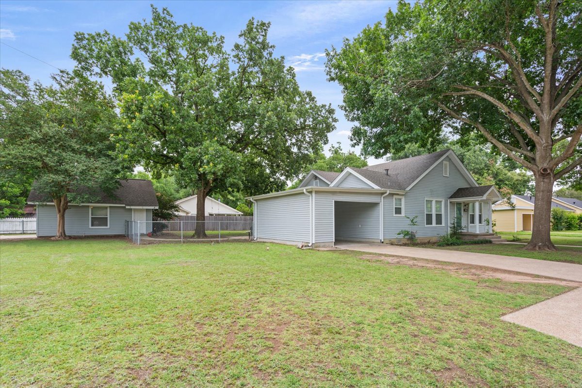 1607 North Harding Avenue Cameron, TX 76520 - Photo 2 of 37 A welcoming light blue home with an attached carport offers ample parking.
