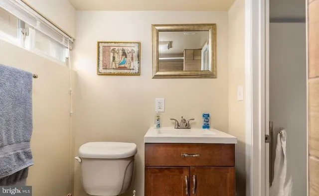 a bathroom with a toilet a sink and mirror