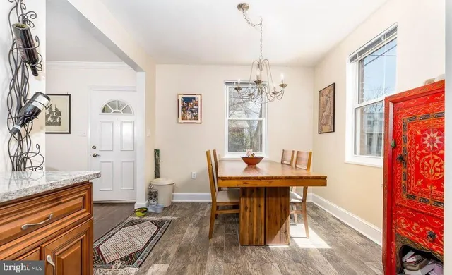 a dining room with furniture a chandelier and wooden floor