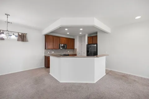 a kitchen with stainless steel appliances granite countertop a refrigerator sink and stove