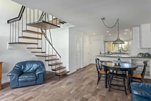 a kitchen with stainless steel appliances granite countertop a table chairs sink and cabinets