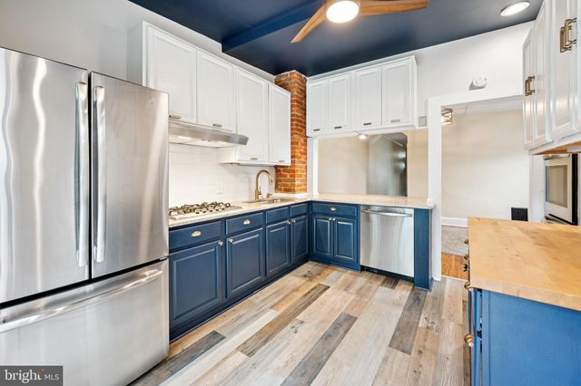 a kitchen with stainless steel appliances a refrigerator and a stove top oven
