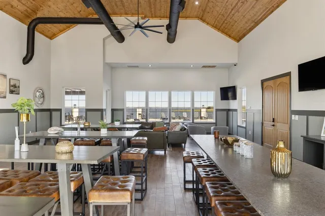 a open kitchen with stainless steel appliances granite countertop a couch dining table and chairs