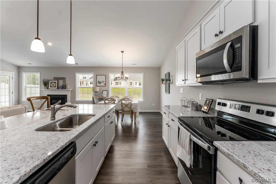 a kitchen with stainless steel appliances granite countertop a sink a stove oven a counter space and cabinets