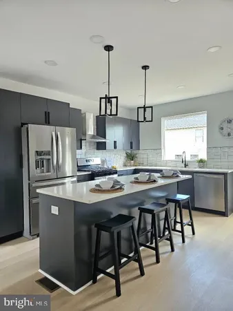 a kitchen with stainless steel appliances granite countertop a sink a stove a refrigerator and island