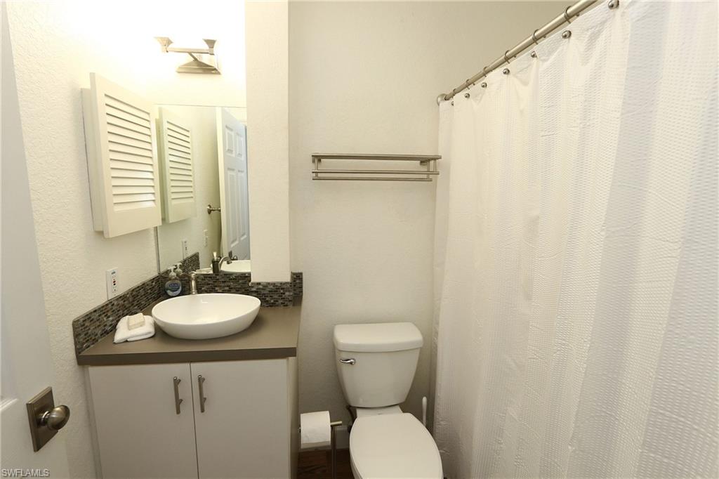 714 11th Street North Naples, FL 34102 - Photo 13 of 27 a bathroom with a sink a toilet and shower curtain